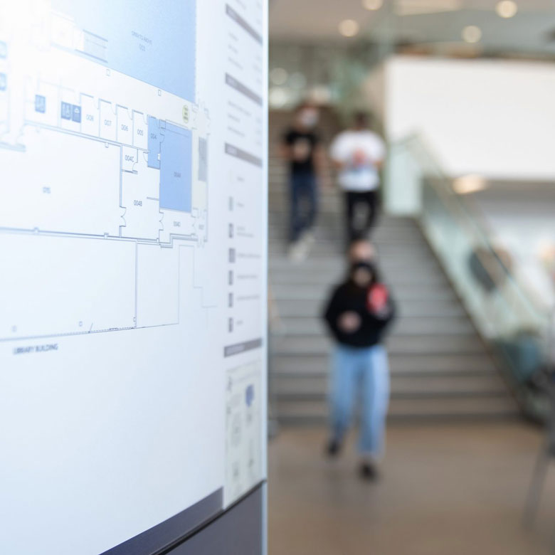 Floorplan of Fitz Hall at UBC Okanagan, with students studying in the background.